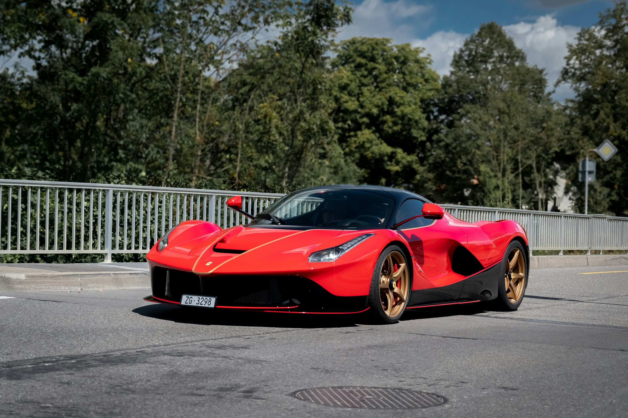 A red Ferrari LaFerrari with sculpted bodywork and a black roof